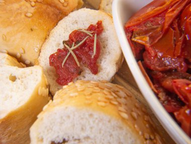 Kurutulmuş domates dolu bir kase. Etrafı susamlı ekmekle çevrili.