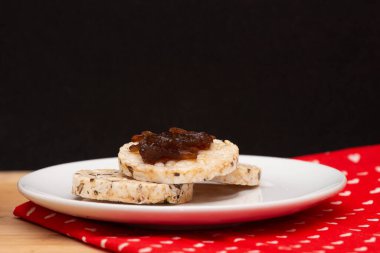 close up of a plate with rice vegan cookies with  jelly on the top beside a bowl full of rice cookies