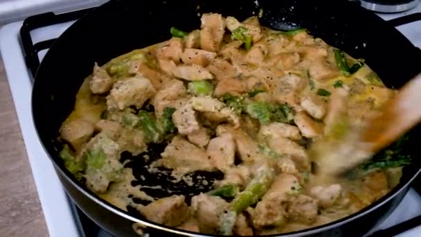 Smażenie Kurczaka Brokułami Czarnej Patelni Mieszanie Kremu Drewnianą Łopatką Gotowanie — Wideo stockowe