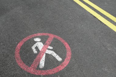 Beyaz yol işaretleme işareti ve beton asfaltta sarı çizgiler. Ulaşım kısıtlamaları yolda. Yayalar giremez, yürümek yok, sadece bisiklete binmek ve araba kullanmak yasak. Kırmızı işaretli..