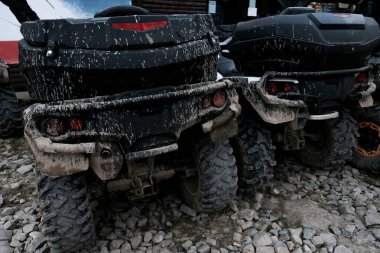 İki kirli çamurlu dörtlü bisikletin arka görüntüsü. Maceracı yaşam tarzı için off-road aşırı ulaşım. Çamura saplandıktan sonra lastikler kirlenir. Yazın 4x4 araç kiralayan macera seyahati.