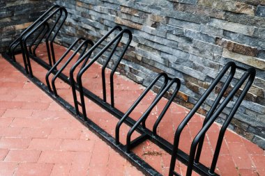 Salgın sırasında boş siyah bisiklet rafı. Otoparkta kimse yok, izolasyonda evde oturmuyorlar. Hava kirliliğini önlemek için taşımacılık için bisiklet kullanmak. Karbon monoksit sorunu için alternatif ulaşım.