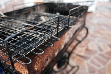 Arka bahçedeki barbekü ızgarasının yakın görüntüsü. Akşam yemeğinden sonra kirli mutfak malzemelerini boşalt. Kömürlü siyah ızgara. Salgın sırasında BBC kutlaması yok. Evdeki sağlıksız yaşam tarzı.