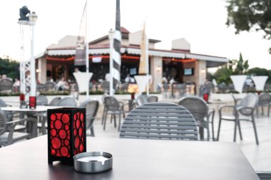 Belek, Türkiye - Ekim 2020: Coronavirus salgını sırasında bir otelde boş bir kafe. Yarısı dolu bir otel, dışarıda takılan neredeyse hiç kimse yok. Restorandaki masada kimse yok, sadece mum ve kül tablası.