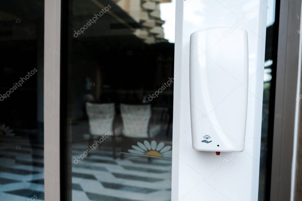 Belek, Turkey - October 2020: Sanitizer device hanging on a hotel territory. Safety measures in all-inclusive hotel to prevent coronavirus spread. Keep hands clean at a five star resort outside.