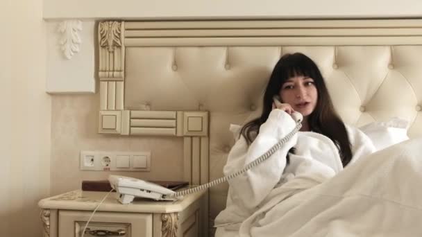 Beyaz Genç Bir Kadın Otel Odasındaki Bir Yatakta Otururken Bornozla — Stok video