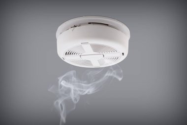 Smoke detector installed on a ceiling clipart
