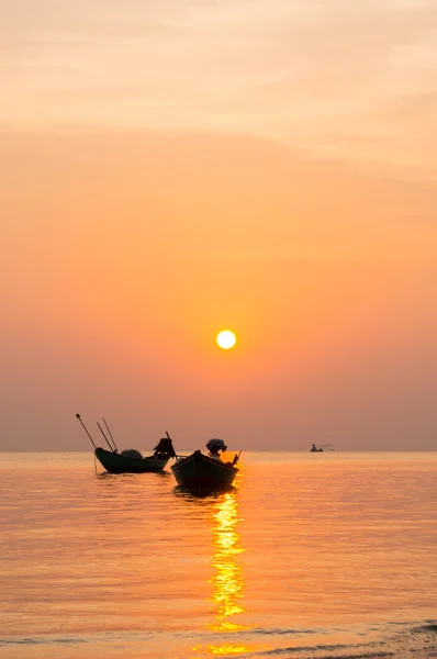 Silhueta de pequenos barcos de pesca no mar durante o nascer do sol — Fotografia de Stock