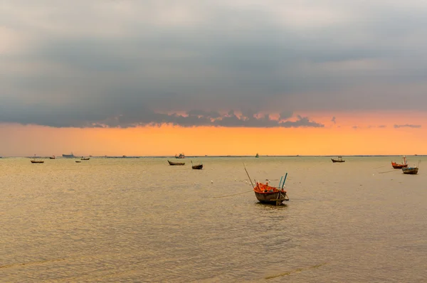 Kleine vissersboten op de zee tijdens zonsondergang en wolken. — Stockfoto