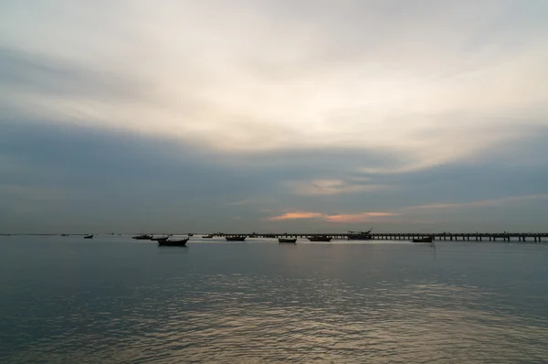 Silhouette kleiner Fischerboote auf dem Meer bei Sonnenuntergang — Stockfoto