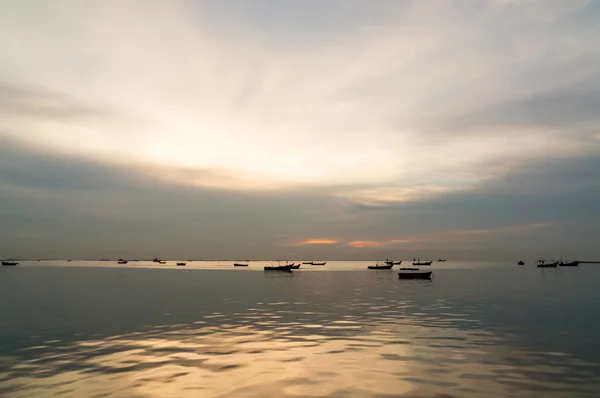 Silhueta de pequenos barcos de pesca no mar durante o pôr do sol — Fotografia de Stock