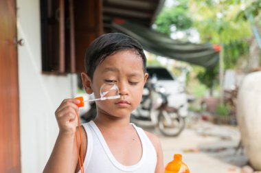 Asyalı çocuk çocuk kabarcıkları ile sabun köpüğü ile oynamak