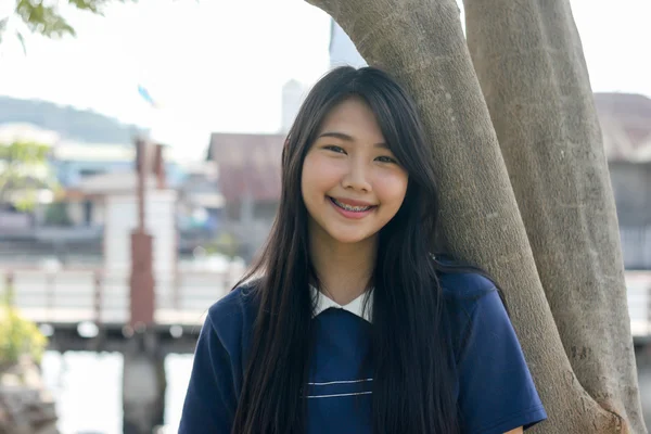 La sonrisa de una joven apoyada en un árbol . —  Fotos de Stock