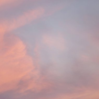 Yumuşak bulutları ve sıcak pastel renkleri olan güzel bir akşam gökyüzü. Hayal kurmak için soyut bir arka plan. Mavi ve turuncunun yumuşak renkleri.