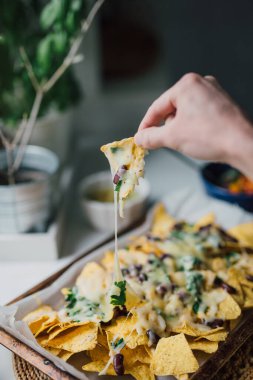 El tabaktan peynirli nacho cipsi çıkarıyor. Ev yapımı Meksika yemeklerini aile ve arkadaşlarla paylaşmak. Otantik insanlar evde vejetaryen sağlıklı atıştırmalıkları pişiriyor. Günlük yaşam tarzı.