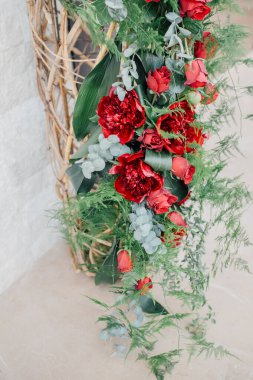 Kırmızı şakayıklı, güllü, yeşil eğreltiotlu ve okaliptüs yapraklı lüks çiçek tasarımı bir düğün ya da şık bir etkinlik için. Modern çiçek aranjmanı. Parti çiçekli süslemesi.   
