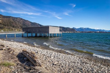 Güneşli bir günde Alplerde iskelesi olan güzel bir göl manzarası.