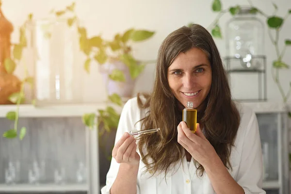 Serum iksiri şişesi açık bir kadın aromasının tadını çıkarıyor.