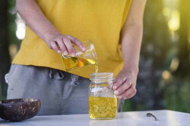 Kadınların elleri açık havada doğal kozmetik ürünlerini temel yağlarla paketliyor.