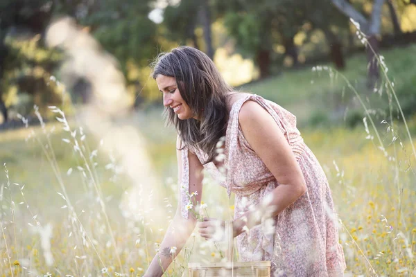 Szczęśliwa Kobieta Zbieranie Dzikich Kwiatów Wiklinowym Koszem — Zdjęcie stockowe