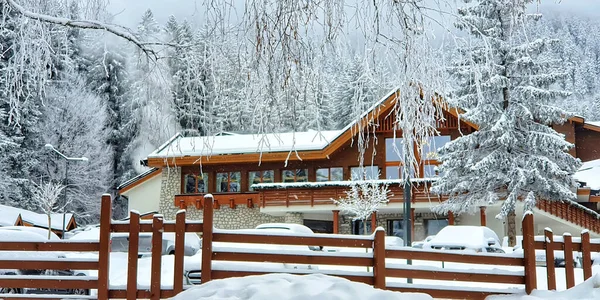 大きな雪が山の中で木造の家を覆った 雪のおとぎ話の冬の風景です 冬のリゾート地のモミの森のヴィラ 山の冬休み ストックフォト