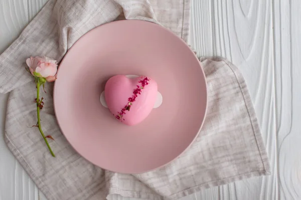 ピンク色の丸皿の上にピンク色のハート型のムースケーキ バレンタインデーおめでとう 女性の日 ロイヤリティフリーのストック画像