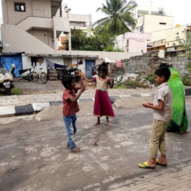 Bangalore, Karnataka / India-Nov 16 Kasım 2020: Farklı yaş grupları ve tatil sırasında Buguri veya Spinning Tops oynayan seks çocuklarının yakın çekimi