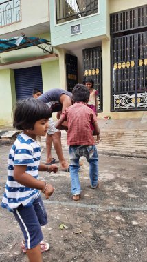 Bangalore, Karnataka / India-Nov 16 Kasım 2020: Farklı yaş grupları ve tatil sırasında Buguri veya Spinning Tops oynayan seks çocuklarının yakın çekimi