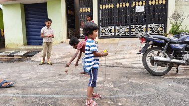 Bangalore, Karnataka / India-Nov 16 Kasım 2020: Farklı yaş grupları ve tatil sırasında Buguri veya Spinning Tops oynayan seks çocuklarının yakın çekimi