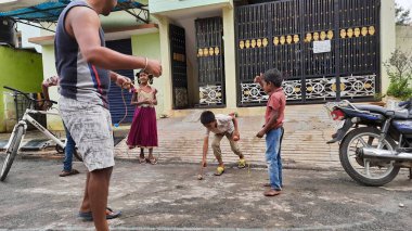 Bangalore, Karnataka / India-Nov 16 Kasım 2020: Farklı yaş grupları ve tatil sırasında Buguri veya Spinning Tops oynayan seks çocuklarının yakın çekimi