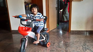 Hintli bir kızın evde küçük bir bisiklete binmesi ya da öğrenmesi.