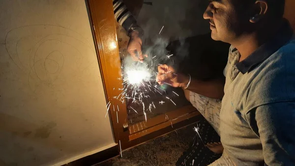 家の外の暗闇の中でインド人の男の燃焼爆竹の閉鎖 — ストック写真