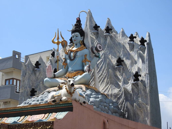 Closeup of beautiful hindu god Lord Shiva Statue at the top of the temple with snow background
