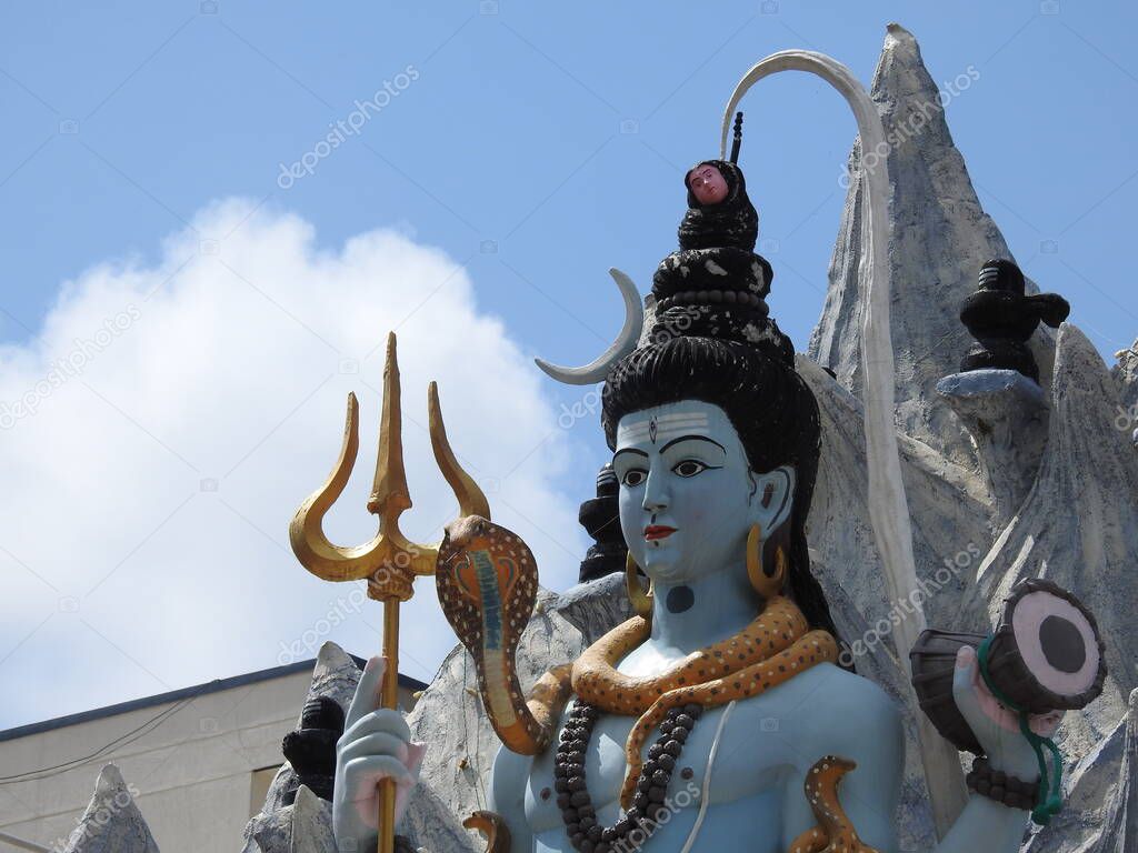Closeup of beautiful hindu god Lord Shiva Statue at the top of the temple with snow background