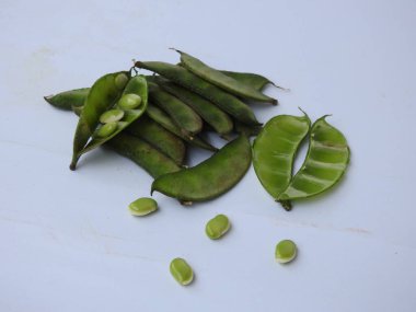 Beyaz arka planda soyulmuş tohumlar olsun ya da olmasın, Hint sümbülü fasulye ya da Avarekai 'nin yakın çekimleri.