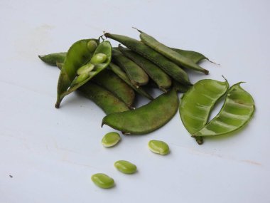 Beyaz arka planda soyulmuş tohumlar olsun ya da olmasın, Hint sümbülü fasulye ya da Avarekai 'nin yakın çekimleri.