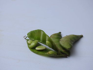 Beyaz arka planda soyulmuş tohumlar olsun ya da olmasın, Hint sümbülü fasulye ya da Avarekai 'nin yakın çekimleri.