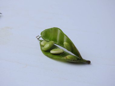 Beyaz arka planda soyulmuş tohumlar olsun ya da olmasın, Hint sümbülü fasulye ya da Avarekai 'nin yakın çekimleri.