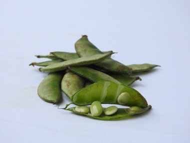 Beyaz arka planda soyulmuş tohumlar olsun ya da olmasın, Hint sümbülü fasulye ya da Avarekai 'nin yakın çekimleri.