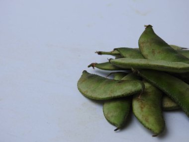 Beyaz arka planda soyulmuş tohumlar olsun ya da olmasın, Hint sümbülü fasulye ya da Avarekai 'nin yakın çekimleri.