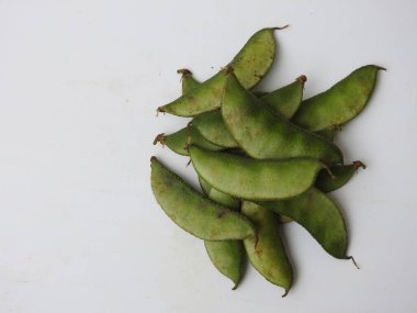 Beyaz arka planda soyulmuş tohumlar olsun ya da olmasın, Hint sümbülü fasulye ya da Avarekai 'nin yakın çekimleri.