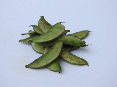 Beyaz arka planda soyulmuş tohumlar olsun ya da olmasın, Hint sümbülü fasulye ya da Avarekai 'nin yakın çekimleri.