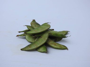 Beyaz arka planda soyulmuş tohumlar olsun ya da olmasın, Hint sümbülü fasulye ya da Avarekai 'nin yakın çekimleri.