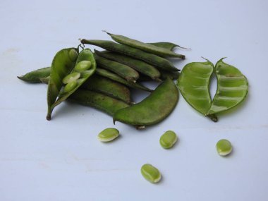 Beyaz arka planda soyulmuş tohumlar olsun ya da olmasın, Hint sümbülü fasulye ya da Avarekai 'nin yakın çekimleri.