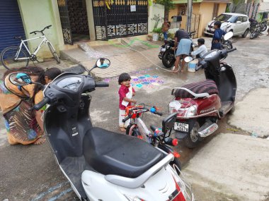 Bangalore, Karnataka, Hindistan-25 Ekim 2020: Dasara Festivali sırasında sokakta Ayudha Puja 'yı kutlayan veya yapan Hintli aile üyeleri grubu