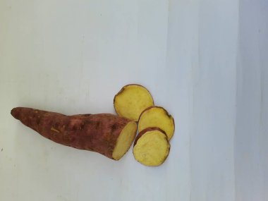 Dışı pembe ve içi sarı renkli tatlı patates yığını beyaz arkaplanda izole edilmiş.