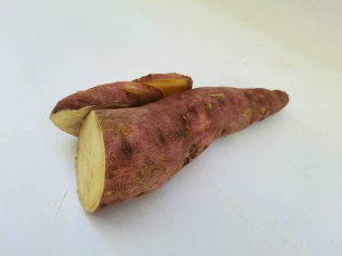 Dışı pembe ve içi sarı renkli tatlı patates yığını beyaz arkaplanda izole edilmiş.