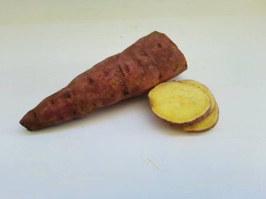 Dışı pembe ve içi sarı renkli tatlı patates yığını beyaz arkaplanda izole edilmiş.