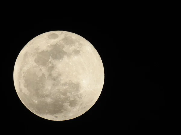 Closeup of Real and Natural Full Moon in the Sky at night at Bangalore, Karnataka, India in a black background