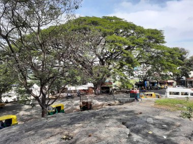 Bangalore, Karnataka, Hindistan-10 Ocak 2021: Gavi Gangadareshwara Tapınağı 'nın giriş kaya veya taşında duran bir grup genç insan ve Korunan Antik Anıt Bilgi Kurulu